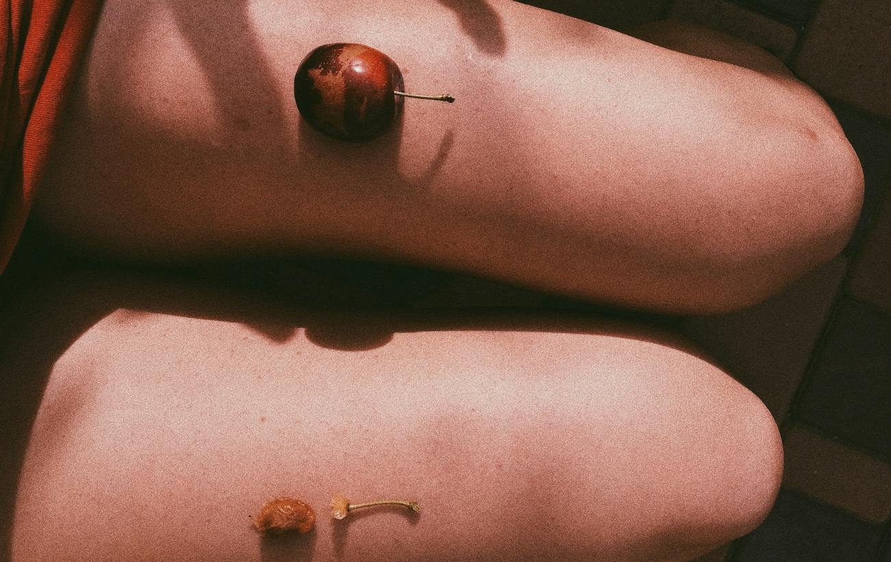 unrecognizable woman eating plums on sunny day