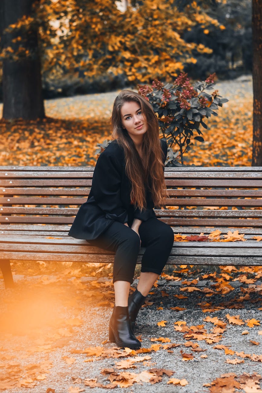 woman wearing black blazer sitting on wooden bench