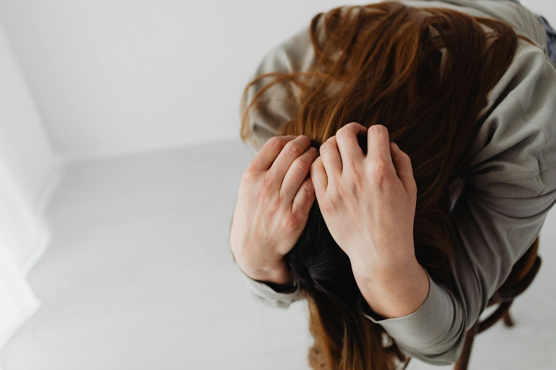 sad woma with hands on hair