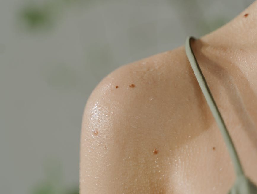 woman in green spaghetti strap top with sweat on body