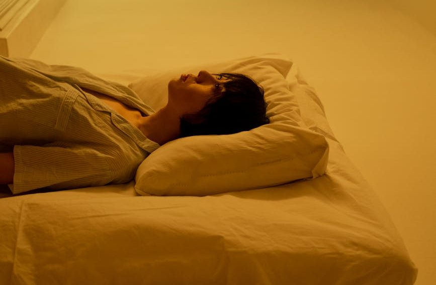 a woman lying on mattress on the floor